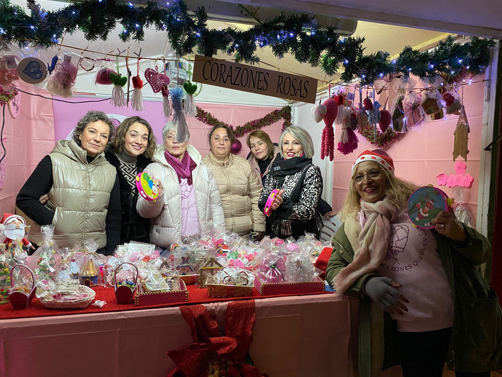 Mercadillo Solidario Navideño Voluntarios de la asociación Corazones Rosas con decoración navideña.